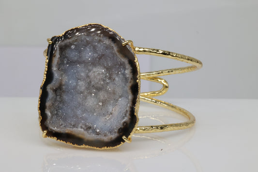 Gold-plated cuff bracelet with natural grey geode slice.
