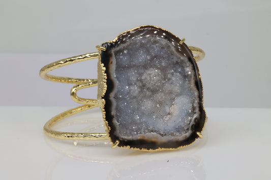 Handmade hammered gold cuff featuring a raw agate geode stone.